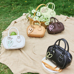 Colorful Amazing Song handbags on picnic blanket with flowers and food outdoors