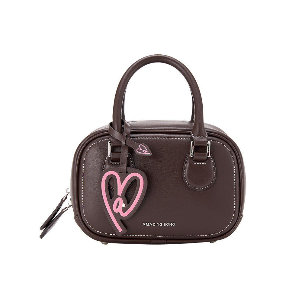 Amazing Song brown handbag with pink heart charm and white stitching detail