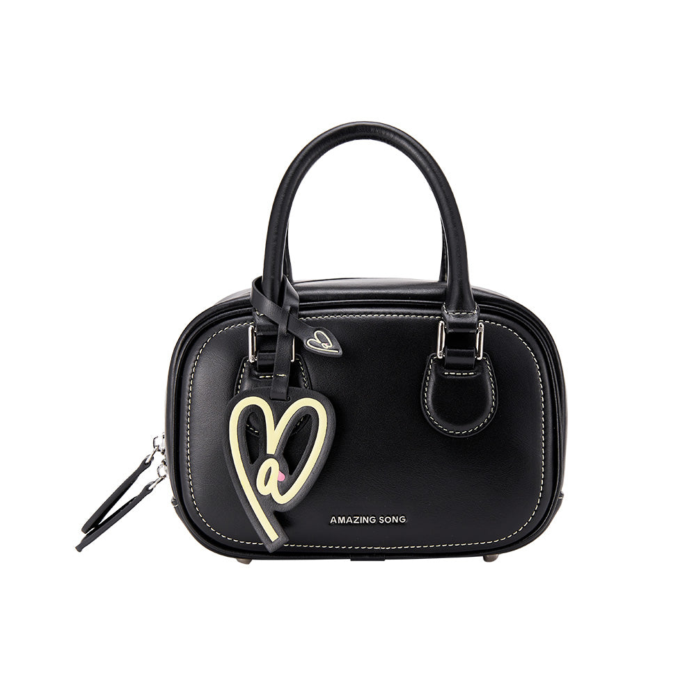 Amazing Song black handbag with heart charm, white stitching, and logo on front