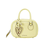 Amazing Song pastel yellow handbag with heart-shaped logo charm, front view