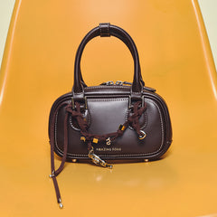 Amazing Song brown leather handbag with braided strap on yellow chair