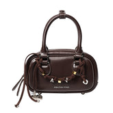Amazing Song brown leather handbag with top handles and decorative chain charm