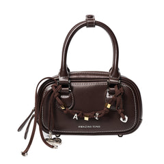 Amazing Song brown leather handbag with top handles and decorative chain charm