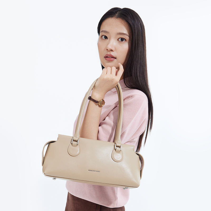 Woman holding beige Amazing Song handbag, fashion accessory, white background