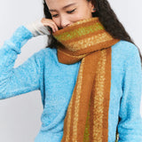 Woman in blue sweater with brown and green wool scarf, Amazing Song official website