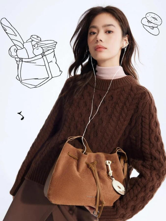 Woman in brown sweater with tan handbag, wearing earphones, Amazing Song official site
