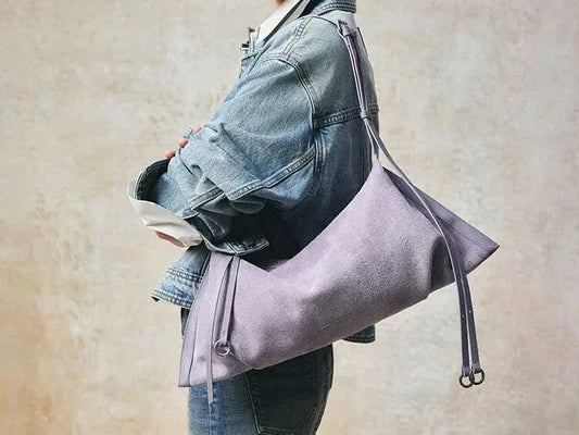 Woman in denim jacket carrying a large lavender suede shoulder bag, Amazing Song style