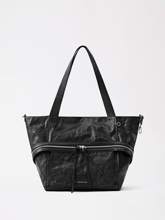 A soft tan cheese-roll leather tote bag resting on a wooden table