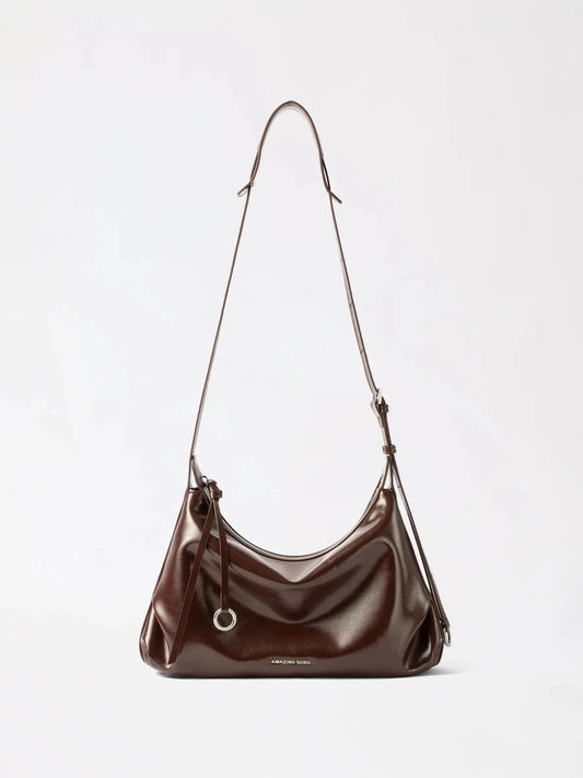 A soft half moon bag in full-grain cowhide leather, curved U-shaped shoulder bag in a warm tan colour