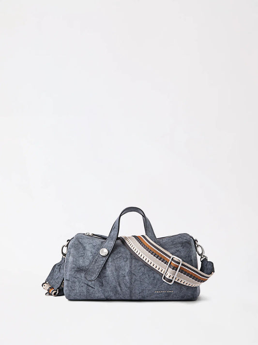 Soft pastel pink berry-shaped leather bag held against a neutral background