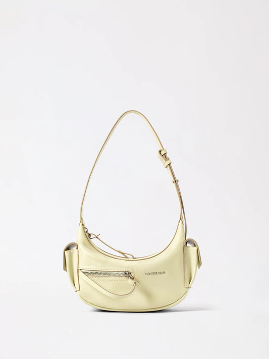 Small crescent shaped leather bag in a warm liqueur tone held in one hand