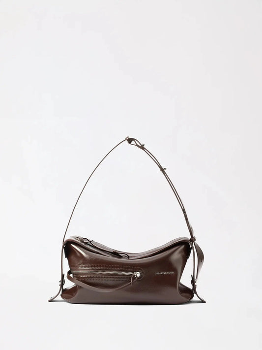 A small rounded top-handle bag in a glossy amber-brown finish with a cute bakery-inspired silhouette