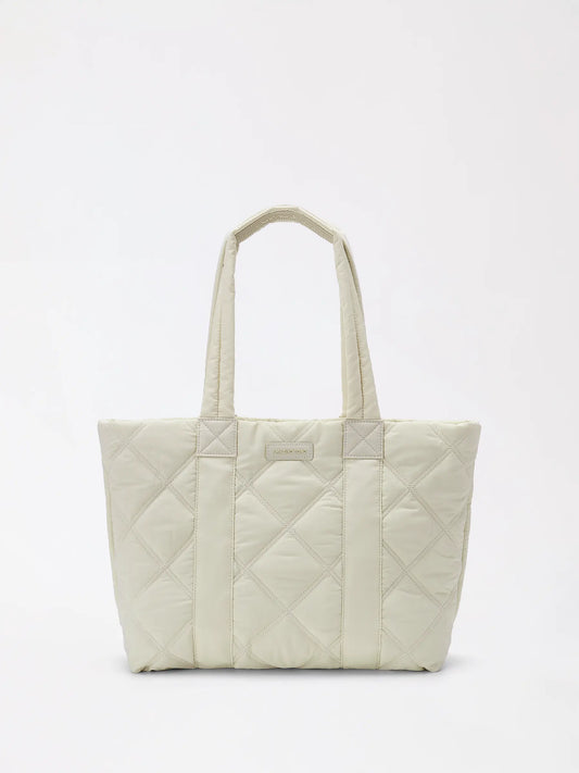 A soft genuine leather down tote bag standing upright on a neutral background