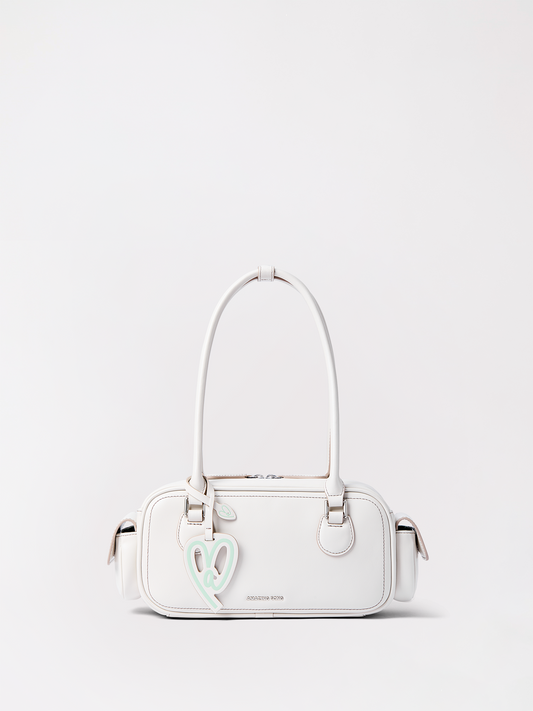 Toast baguette in top-grain leather resting on a neutral surface, a long bakery-inspired crossbody for everyday carry