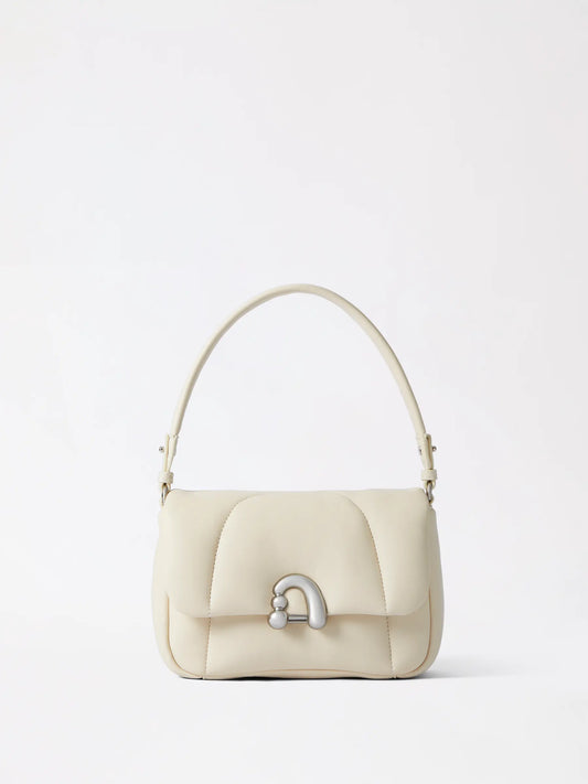 Medium structured leather everyday bag standing upright on a shelf with its shape fully supported by gentle stuffing