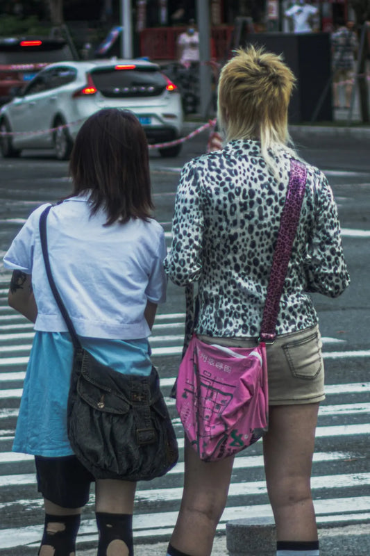 2 women walking on sidewalk during daytime