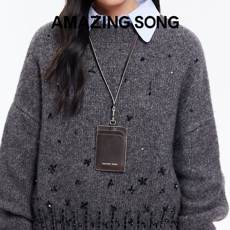 Amazing Song card holder on lanyard, worn over gray beaded sweater, official website promo