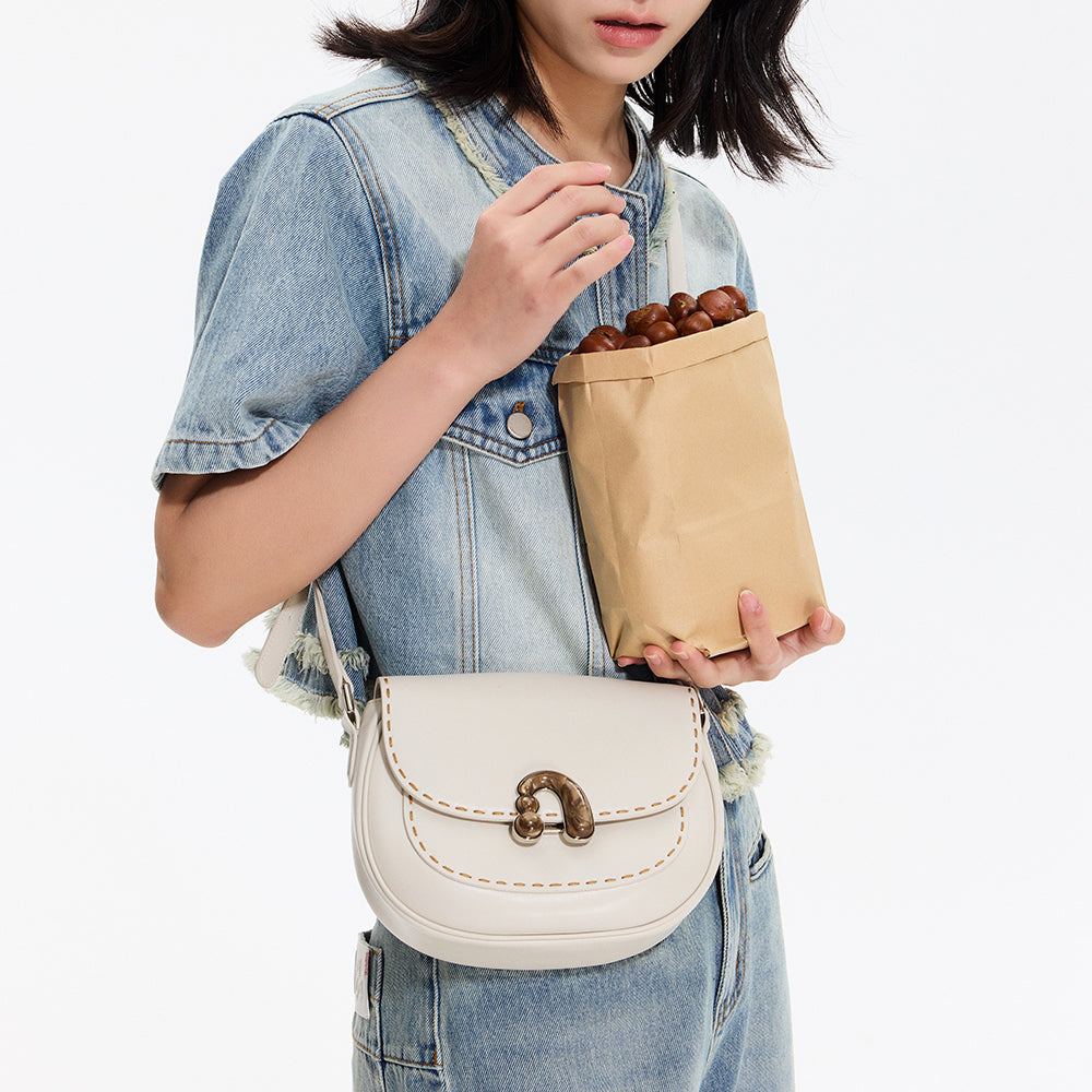 Woman in denim outfit holding white crossbody bag and paper bag of chestnuts, Amazing Song