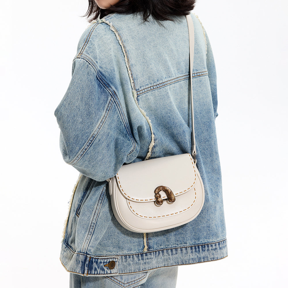 Woman in denim jacket with white crossbody bag, Amazing Song fashion accessory