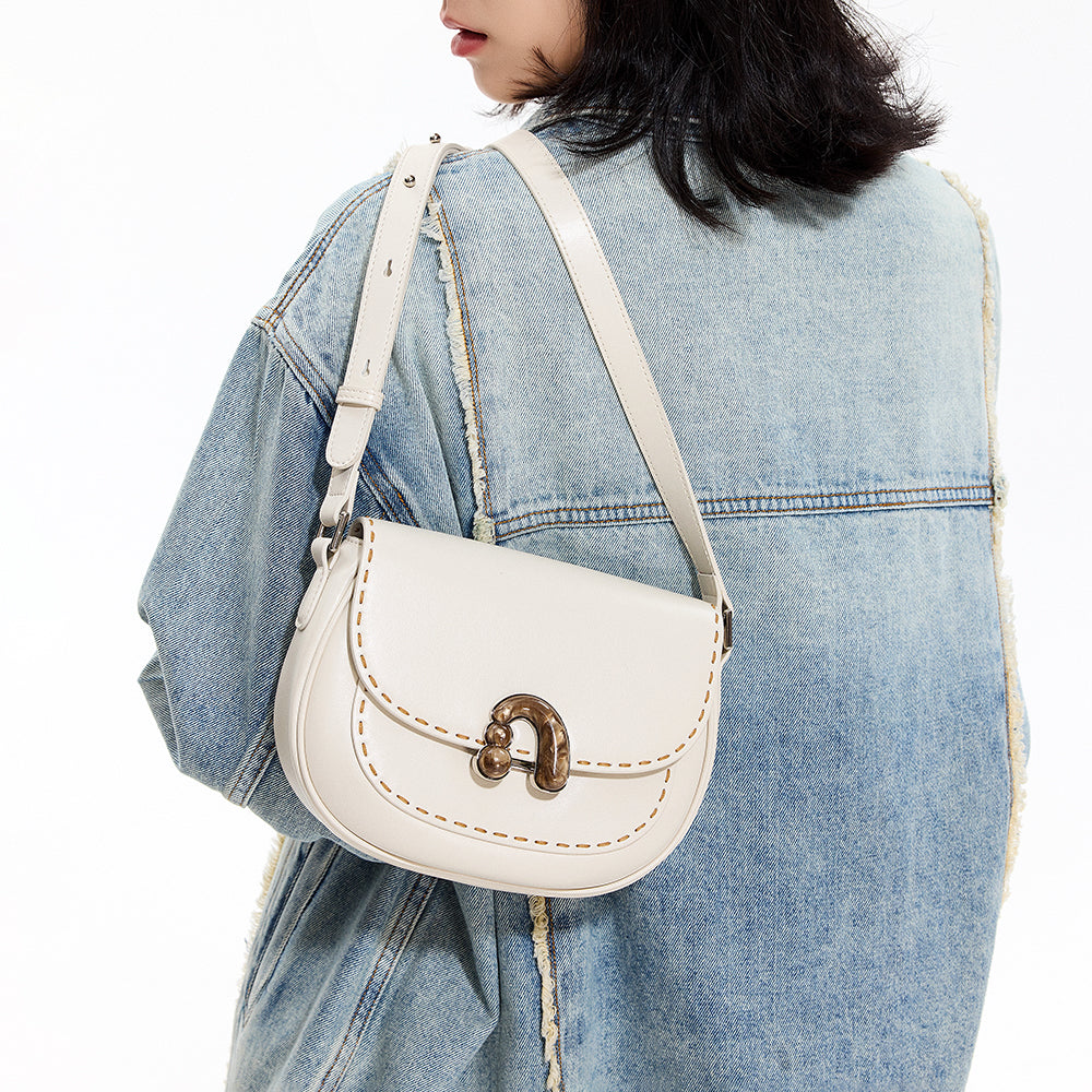Woman in a denim jacket carrying a white leather shoulder bag with gold clasp, Amazing Song