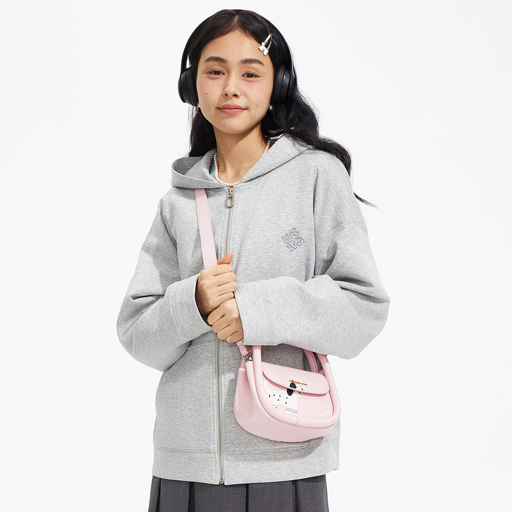 Young woman in gray hoodie with headphones and a pink cartoon crossbody bag, Amazing Song