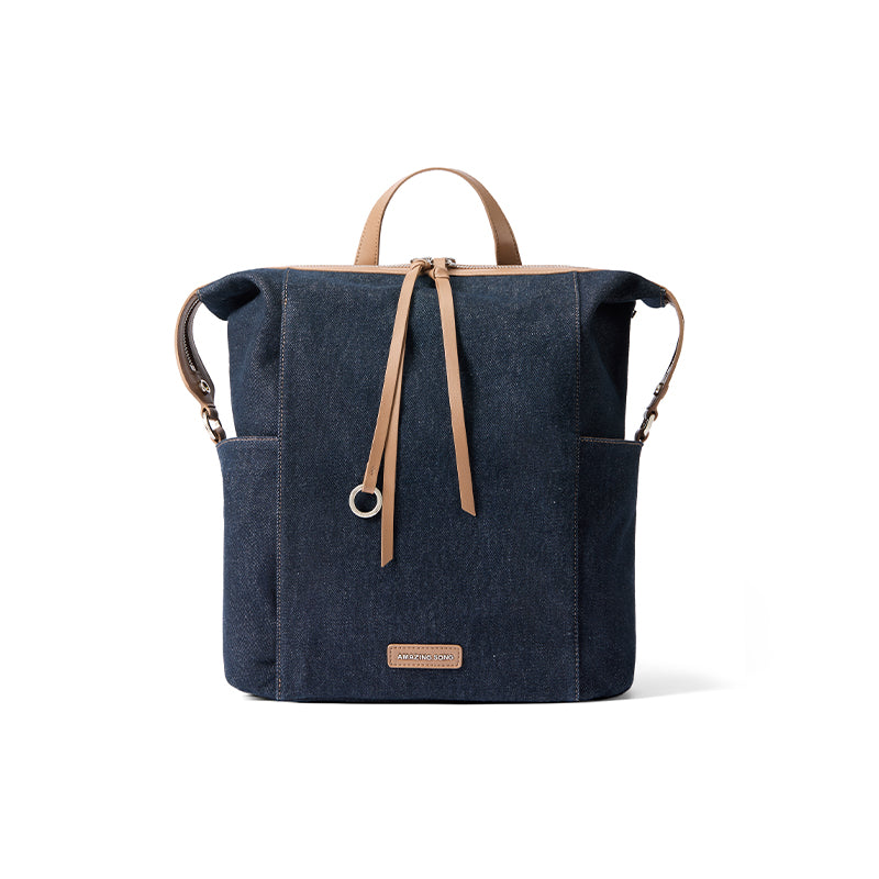 Amazing Song navy denim backpack with tan leather straps on white background