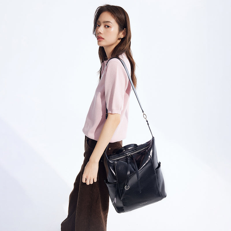 Woman in light pink top carrying large black leather shoulder bag, Amazing Song style