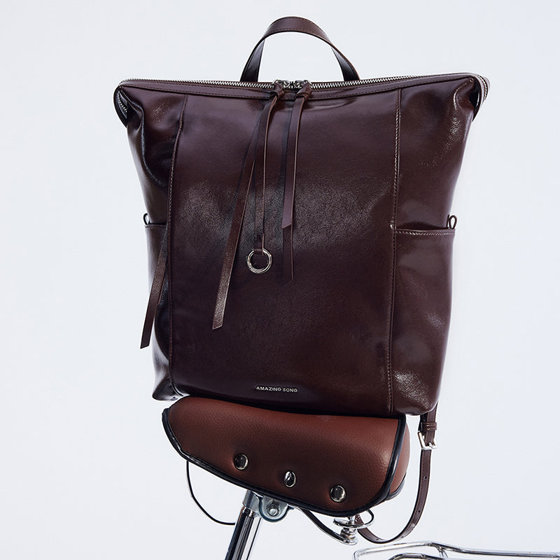 Amazing Song brown leather backpack with zipper on bicycle seat, minimalist design