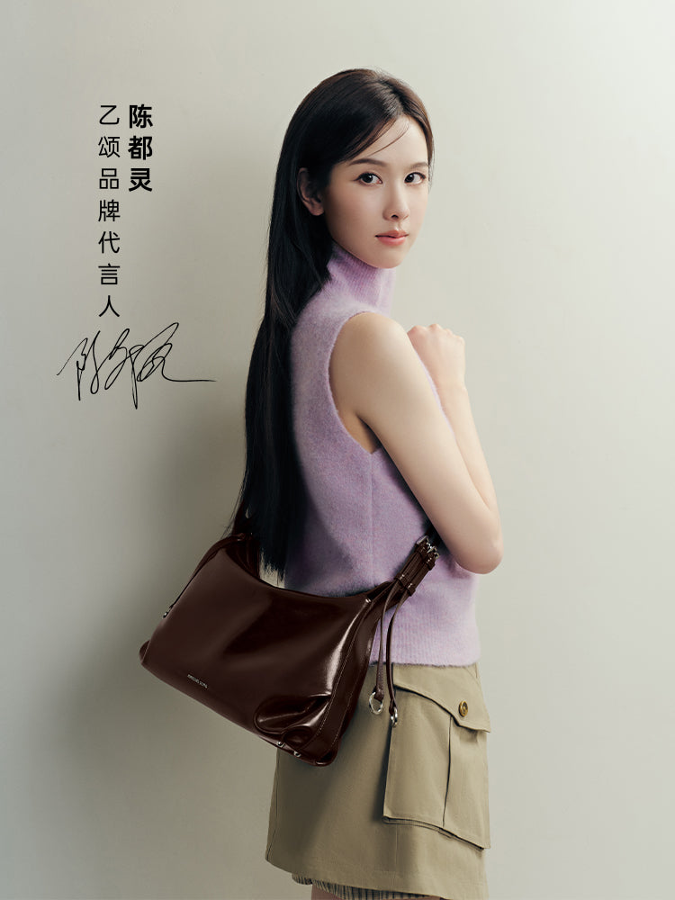 Woman in pastel sleeveless top with brown leather shoulder bag, Amazing Song official site