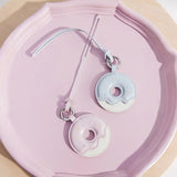 Pastel donut-shaped Amazing Song keychains on a pink tray