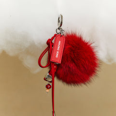 Amazing Song red fluffy keychain with tag and beads on beige background