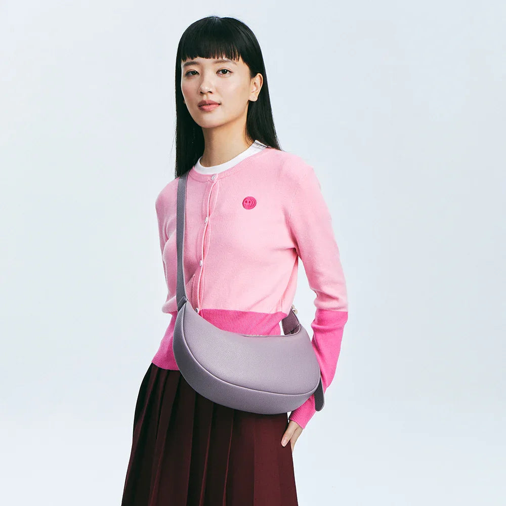 Woman in pink cardigan with purple crossbody bag, Amazing Song official website style