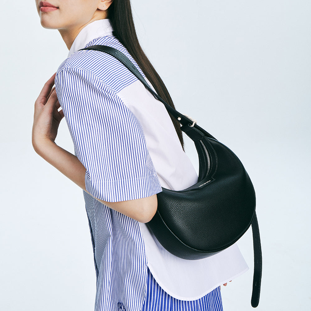 Woman in striped shirt carrying black leather shoulder bag, Amazing Song fashion