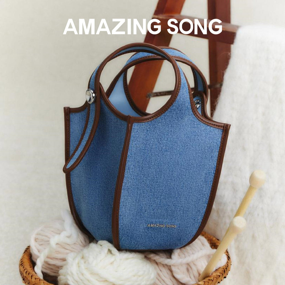 Amazing Song blue denim handbag with brown trim, basket of yarn, cozy home setting