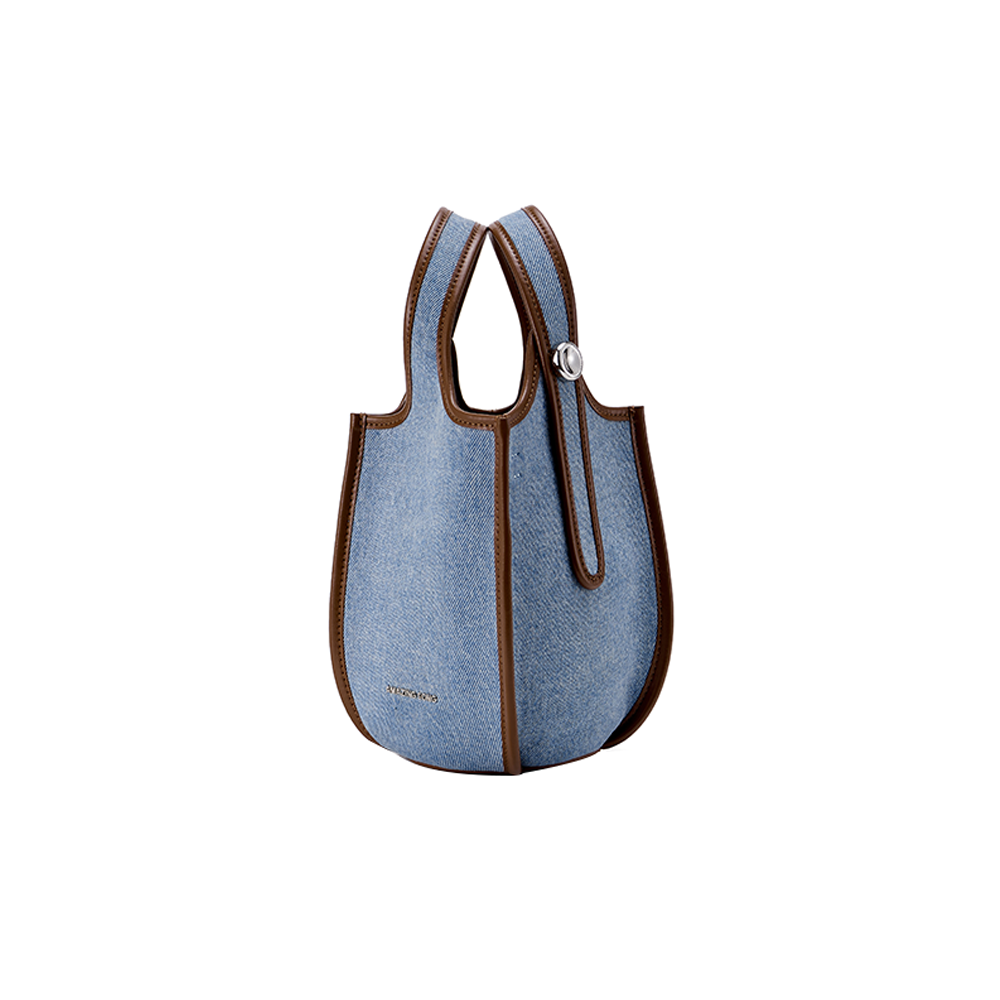 Light blue denim tote bag with brown leather trim, displayed on white background