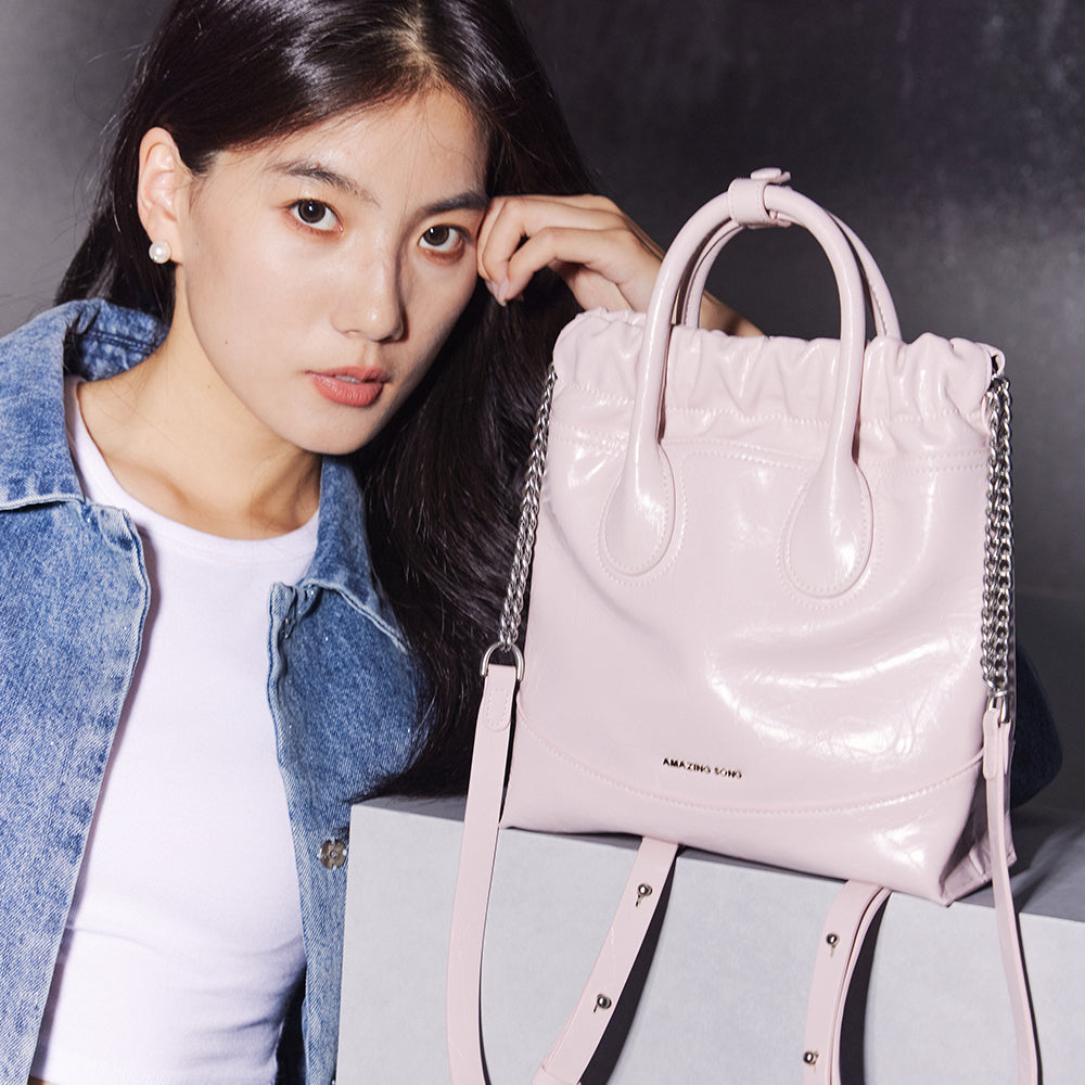 Woman in denim jacket with pale pink Amazing Song handbag, official website promo
