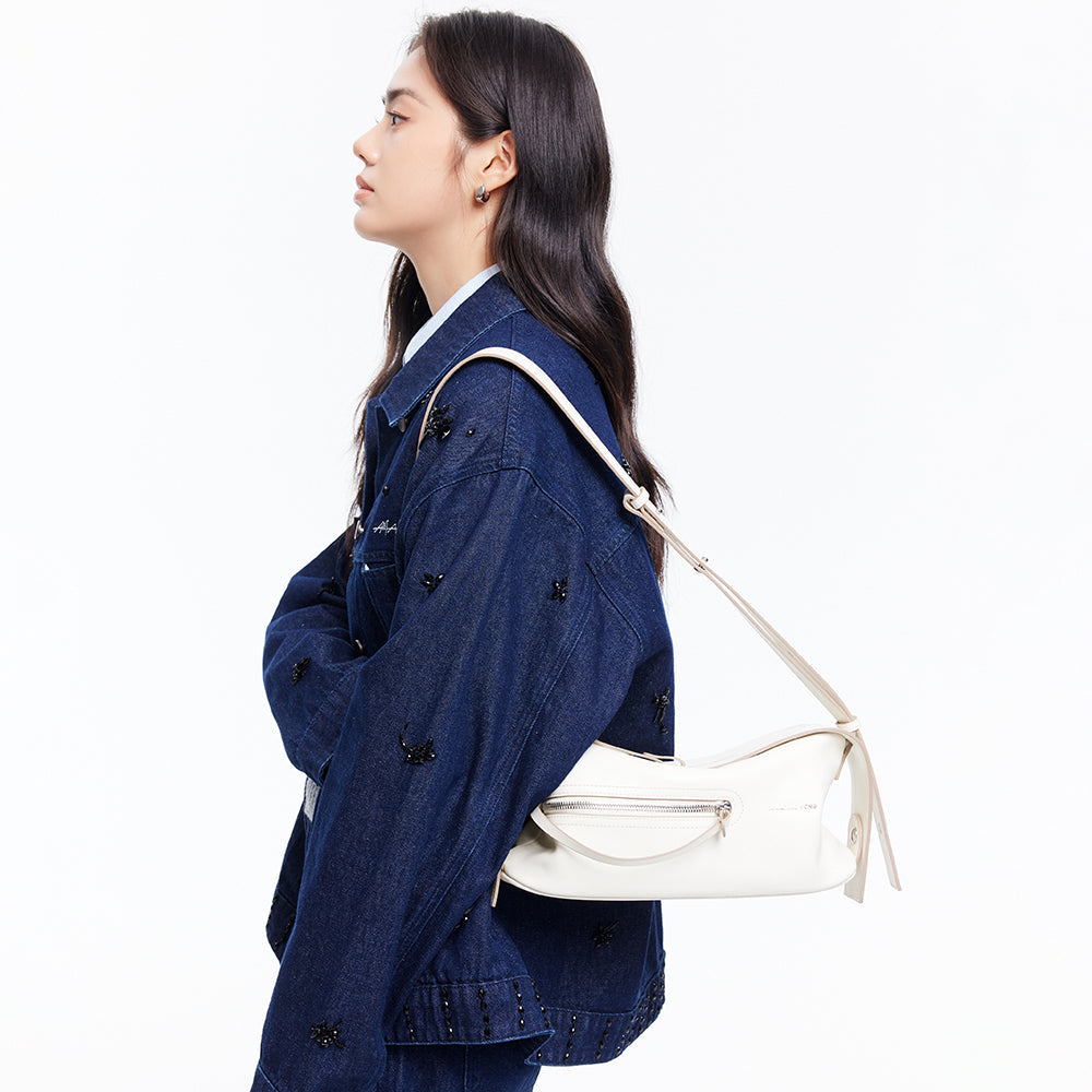 Woman in blue embellished denim jacket carrying a white shoulder bag, Amazing Song