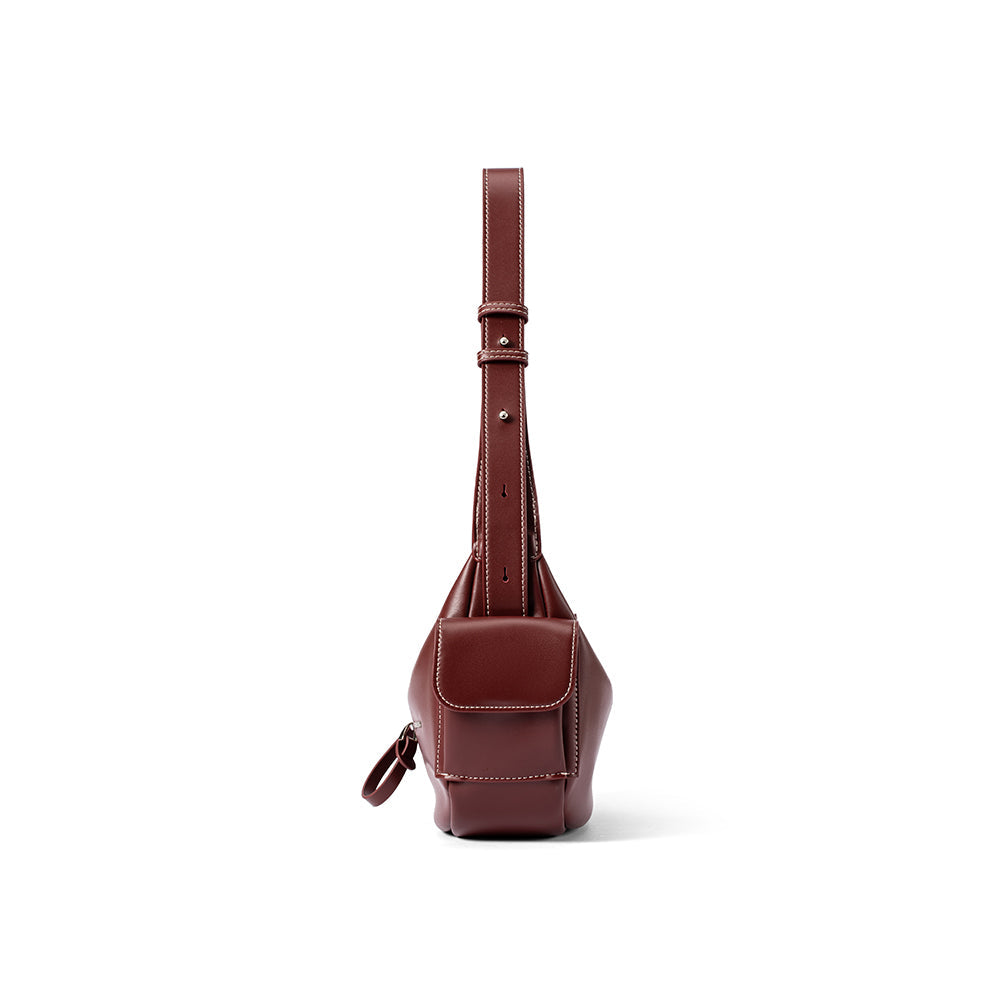 Front view of a brown leather sling bag with white stitching, Amazing Song website product.