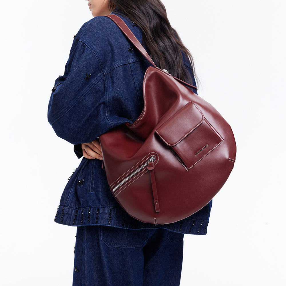 Woman in denim outfit carrying a burgundy leather backpack from Amazing Song