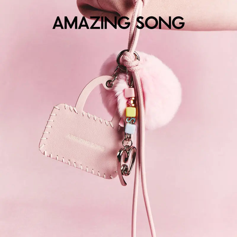 Amazing Song pink leather bag charm with pastel beads and fluffy pompom on pink background