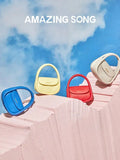 Amazing Song designer handbags in blue, yellow, red, and cream on pink textured surface, sky background