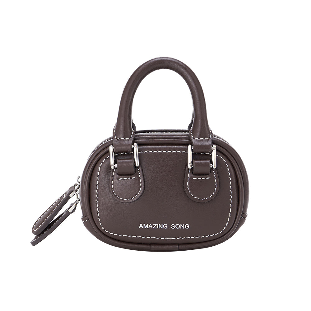 Amazing Song brown mini handbag with dual handles and white stitching, studio background