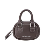 Amazing Song brown mini handbag with dual handles and white stitching, studio background