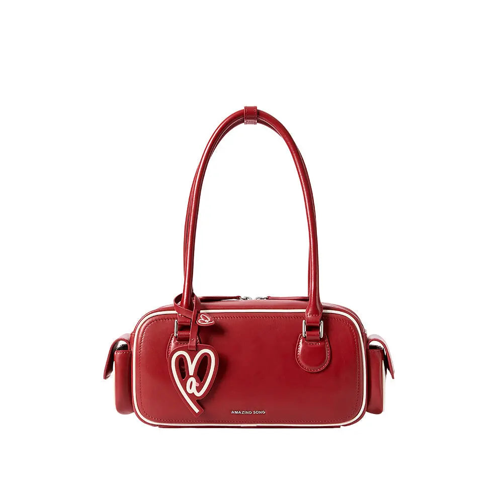 Amazing Song red handbag with heart charm and double handles on white background