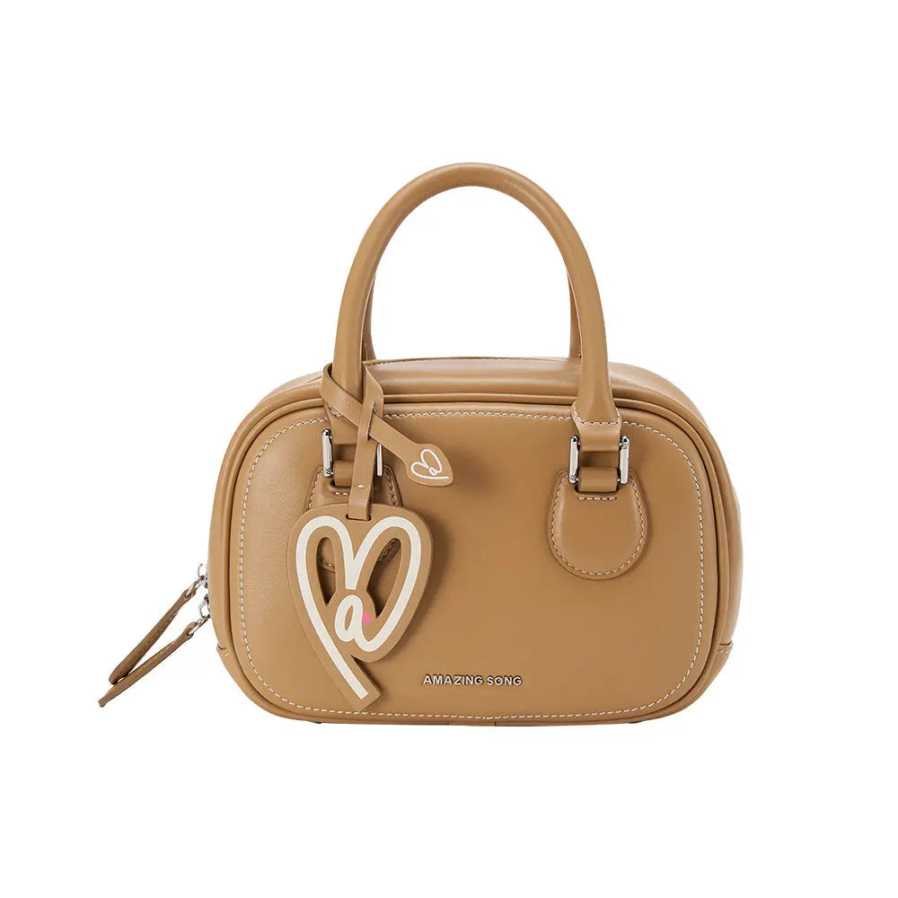 Amazing Song tan leather handbag with heart keychain and logo