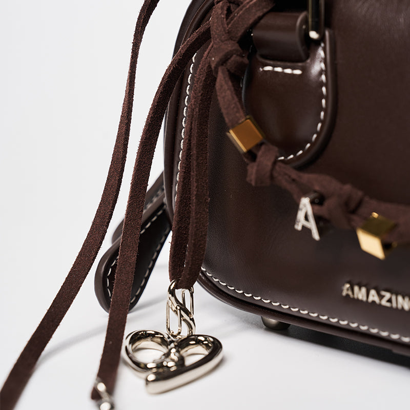 Amazing Song brown leather bag with suede tassels, metal heart charm, and white stitching