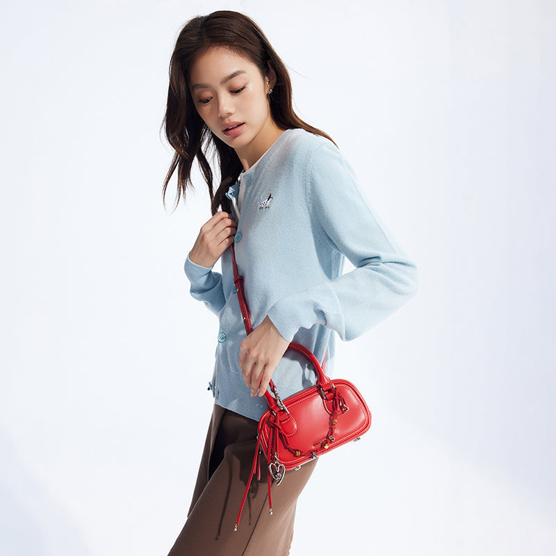 Woman in light blue cardigan with red handbag, Amazing Song fashion, white background