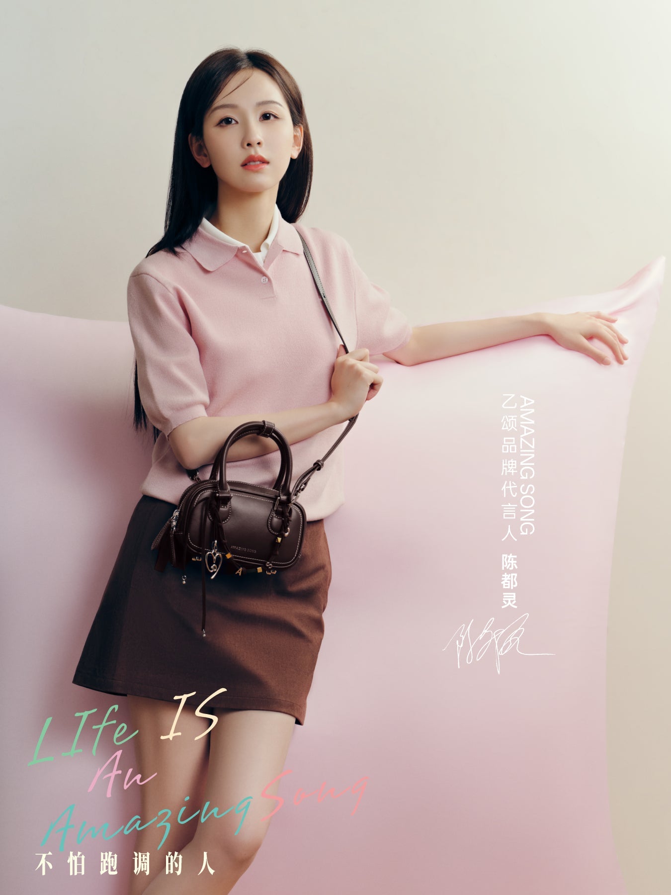 Young woman in pink top and brown skirt holding black handbag, Amazing Song brand promo